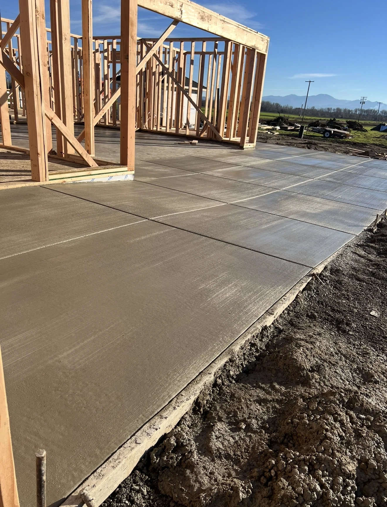 New concrete slab beside framed building walls