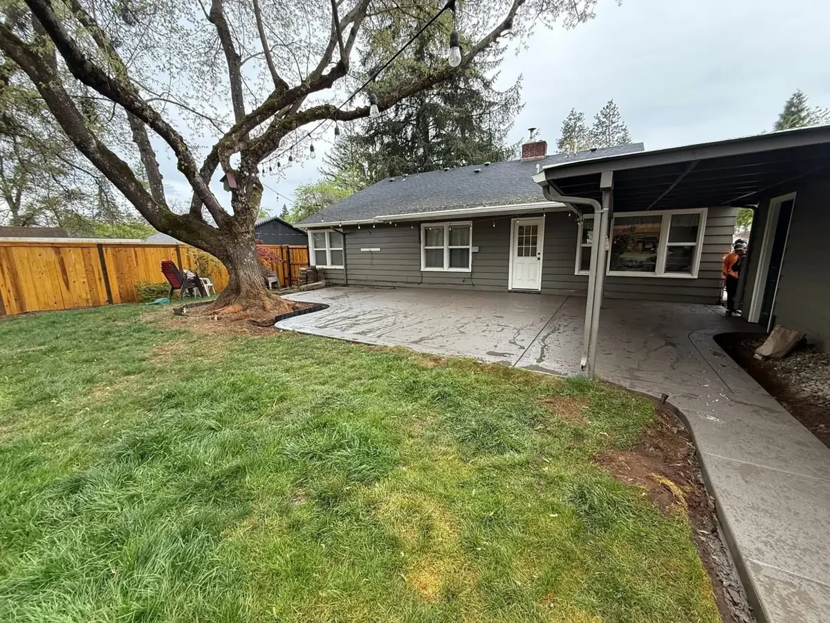 Concrete patio beside a home and lawn
