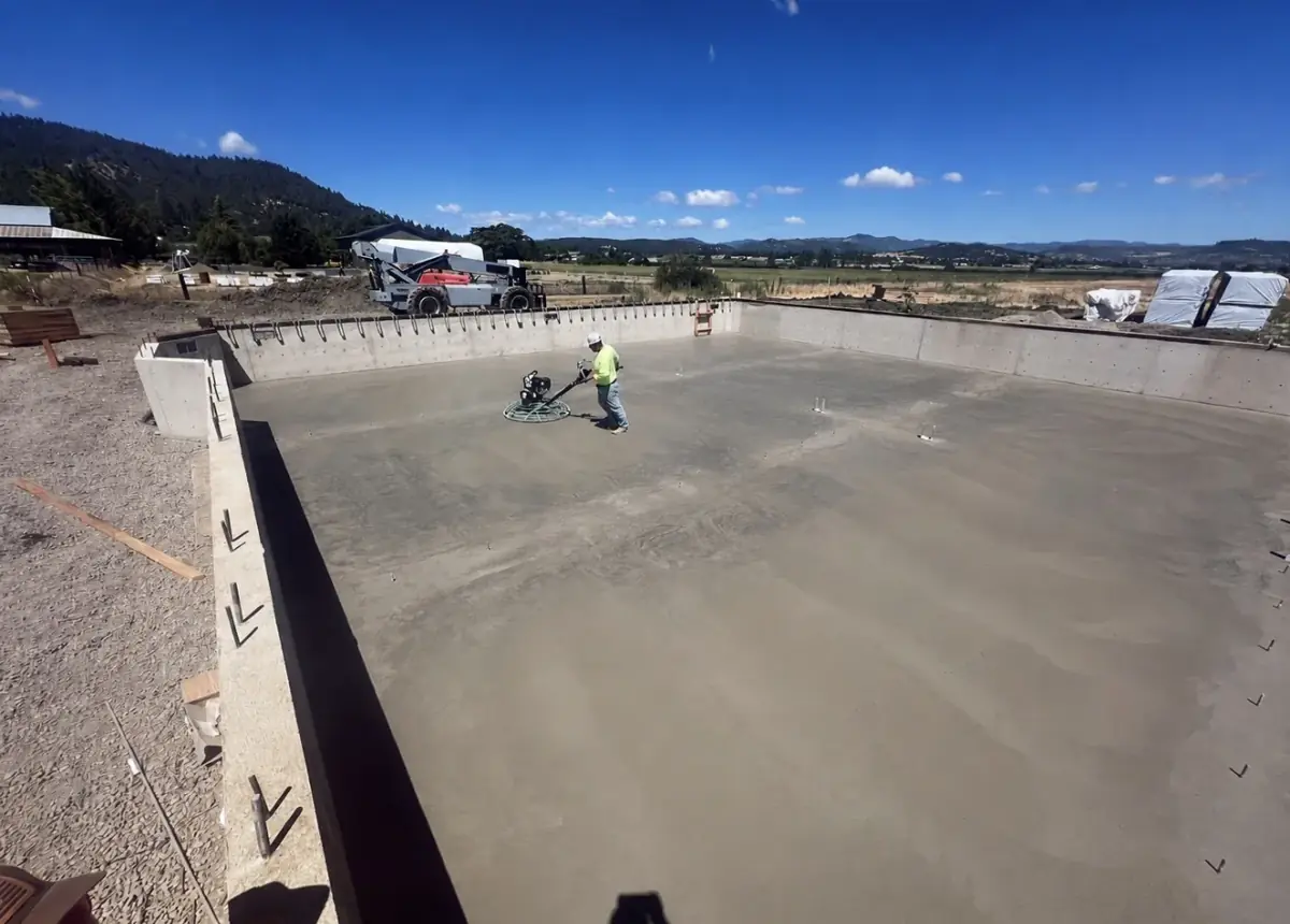 Concrete slab work beside a framed building